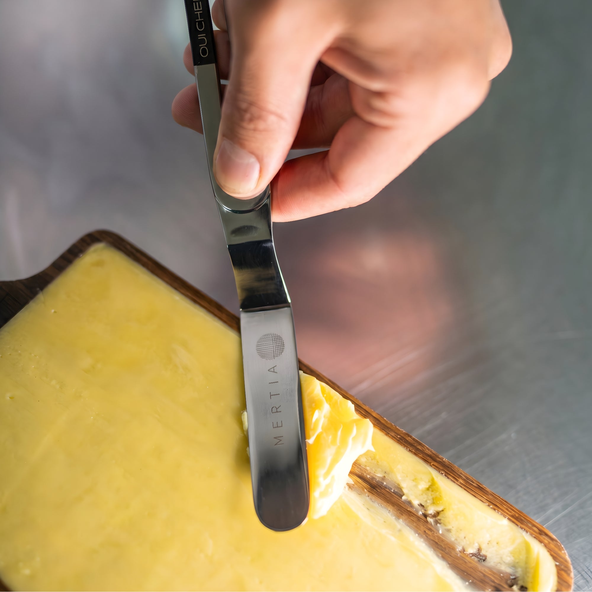 Chef delicately spreading butter with a small stainless steel palette knife .