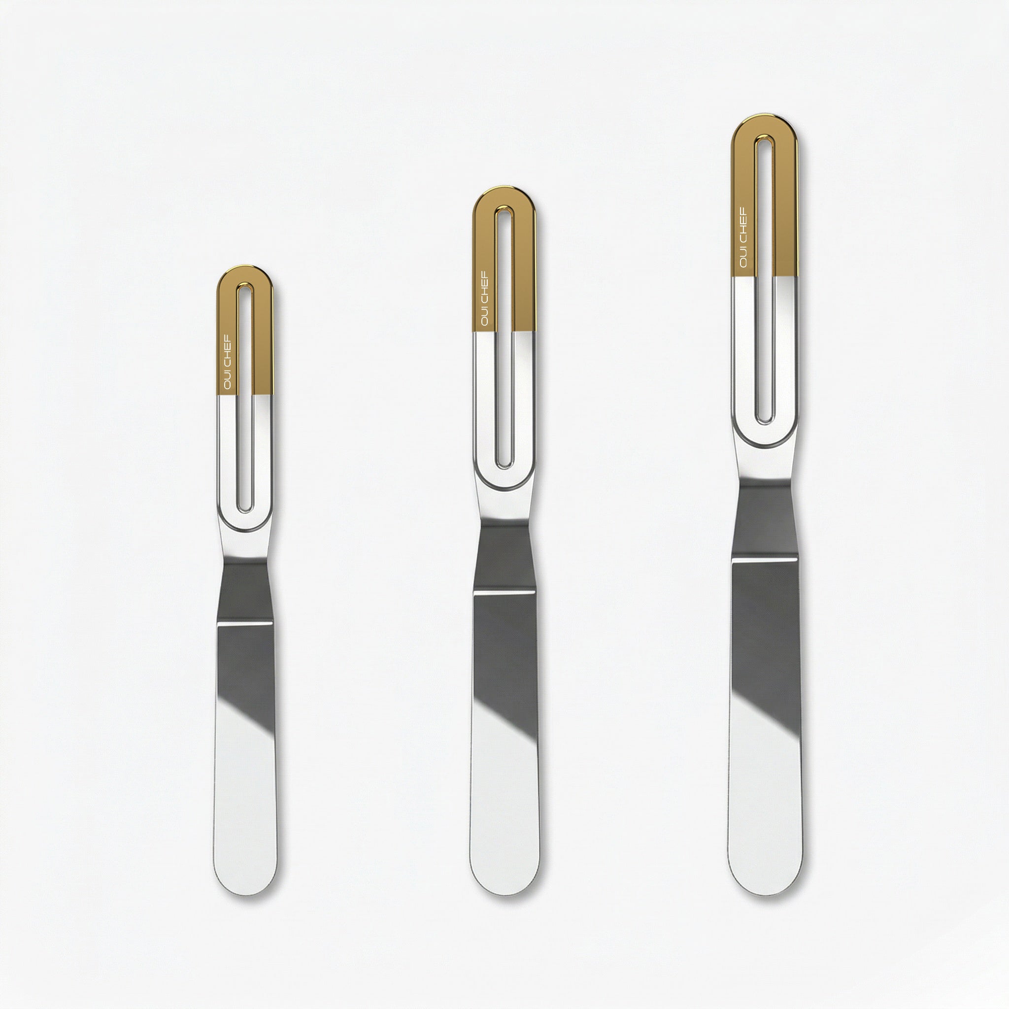 Three stainless steel offset palette knives of increasing size, each with a sleek metal blade and a gold ergonomic handle labeled “OUICHEF,” arranged side by side on a light background.