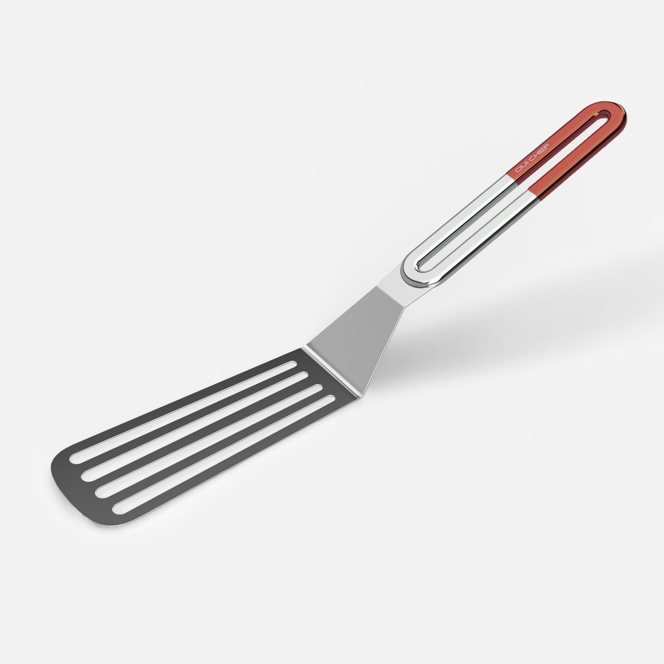 A stainless steel slotted spatula with a copper coloured handle against a white background.